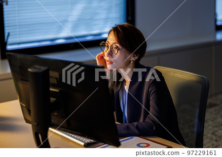 Business woman staying in the company and working late 97229161