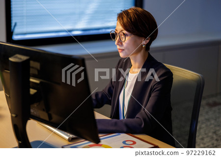 Business woman staying in the company and working late 97229162
