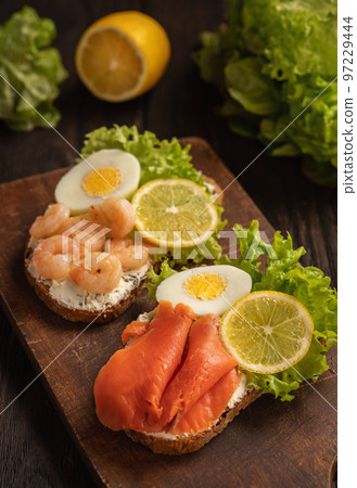 The toasts with boiled eggs, salad lettuce, lemon slime, shrimps and smoked salmon. The toasts with boiled eggs, salad lettuce, lemon slime, shrimps and smoked salmon. 97229444