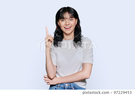 Happy young woman showing index finger up, over white background 97229453
