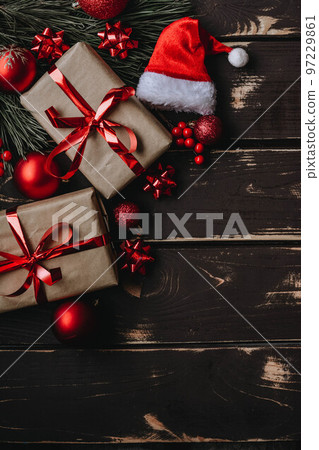 Christmass background gift boxes,red christmas tree toys,Santa hatn and spruce brance on wooden background. Christmass background gift boxes,red christmas tree toys,Santa hatn and spruce brance on wooden background. 97229861
