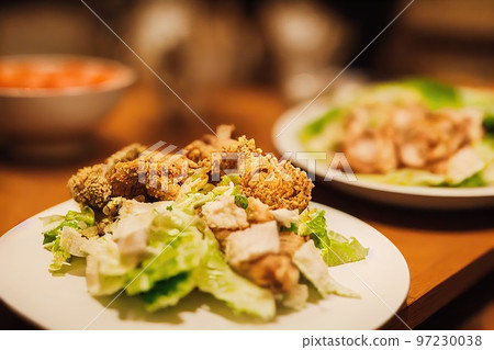 Plate of delicious healthy chicken caesar salad with cheese and fresh lettuce leaves Plate of delicious healthy chicken caesar salad with cheese and fresh lettuce leaves 97230038