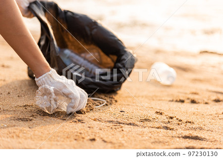 Volunteer woman picking plastic bottle into trash plastic bag black for cleaning the beach, female clean up garbage, Ecology concept and World Environment Day, Save earth concept Volunteer woman picking plastic bottle into trash plastic bag black for cleaning the beach, female clean up garbage, Ecology concept and World Environment Day, Save earth concept 97230130