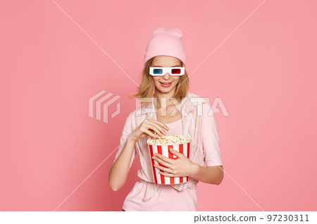 pretty blonde girl holding bucket of popcorn pretty blonde girl holding bucket of popcorn 97230311