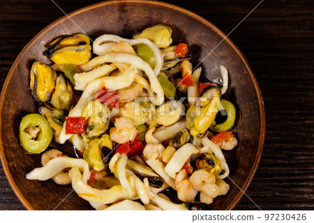 Seafood salad with shrimp, squid and mussels on wooden table 97230426