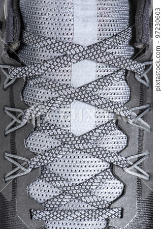 Sneakers close-up. Shoelaces of new sports shoes in gray, lacing sneakers close-up, top view. Mesh elastic laces for fitness. Sport and active lifestyle concept. 97230603