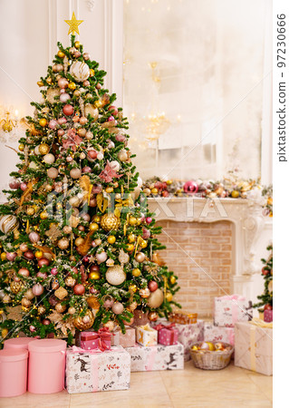 A large beautiful traditional Christmas tree with gifts in a classic interior. 97230666