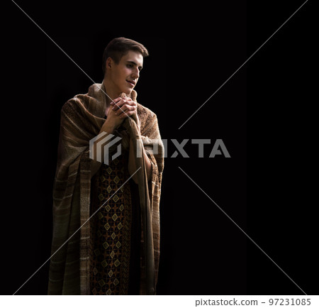 Praying man with wooden cane 97231085
