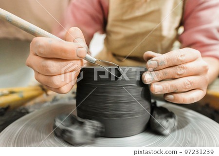 The master of sculpting pottery working in a studio 97231239