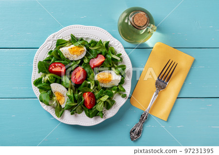 Salad of lambs lettuce, boiled egg and tomato. 97231395
