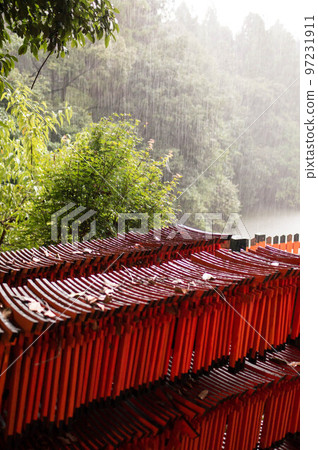 A small torii gate that gets wet at Fushimi Inari Taisha in the rain in Kyoto A small torii gate that gets wet at Fushimi Inari Taisha in the rain in Kyoto 97231911