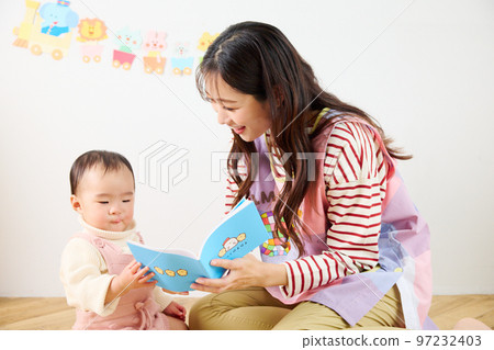 nursery teacher playing with baby 97232403
