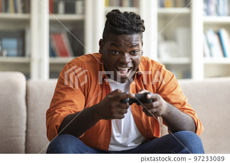 Handsome young black man playing video games at home 97233089