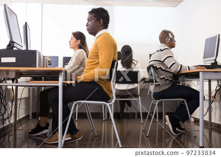 Young adult man studying in computer class Young adult man studying in computer class 97233834