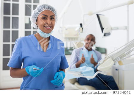 Successful professional woman dentist standing in dental office 97234041