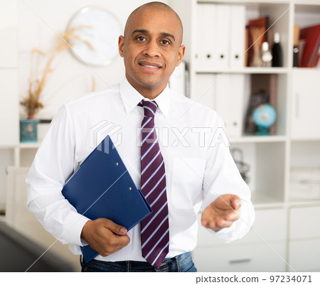 Manager in office standing near workplace Manager in office standing near workplace 97234071