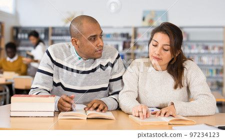 Latin american man and woman studying in university library 97234123