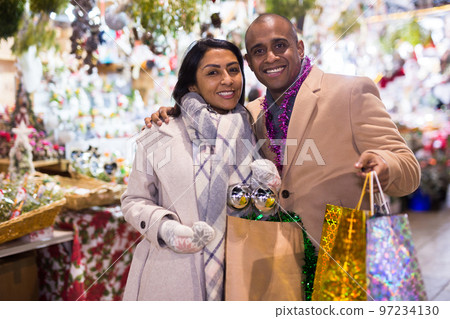 Portrait of happy elegant couple with gift bags at new year fair Portrait of happy elegant couple with gift bags at new year fair 97234130