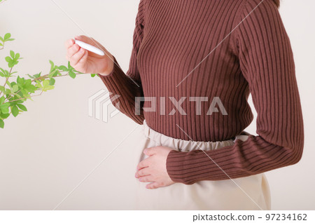 一個女人在看試驗藥時摸著她的肚子 一個女人在看試驗藥時摸著她的肚子 97234162