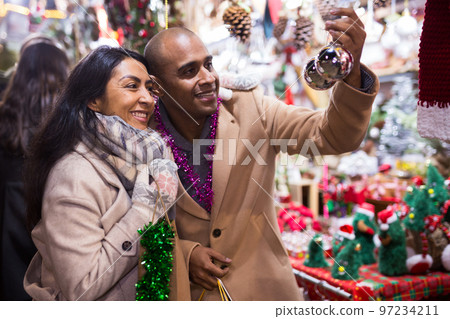 Emotional happy couple buying christmas balls at christmas fair 97234211