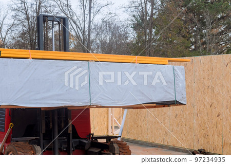 Construction building materials are being unloaded with help of forklift in construction site 97234935