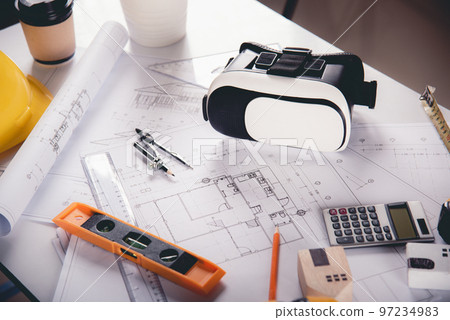 Architect workplace top view. Architectural blueprint paper project plans on desk table, tool for engineer contractor building design working drawing and VR glasses, industry virtual technology Architect workplace top view. Architectural blueprint paper project plans on desk table, tool for engineer contractor building design working drawing and VR glasses, industry virtual technology 97234983
