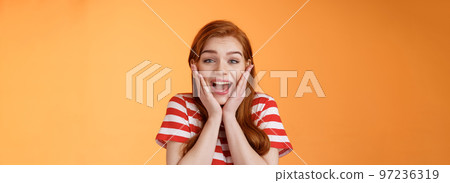Close-up cute redhead cheerful girl look amazed yelling from joy lucky achieve best score, got scholarship, woman receiving stunning news, unbelievable success, smiling broadly, touch cheeks 97236319