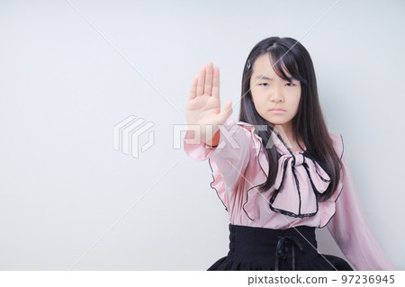 A girl who gives a signal to stop and glares 97236945
