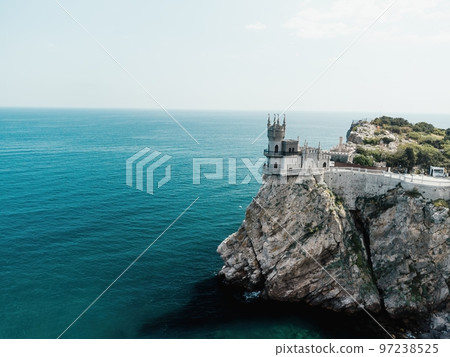 Crimea Swallow's Nest Castle on the rock over the Black Sea. It is a tourist attraction of Crimea. Amazing aerial view of the Crimea coast with the castle above abyss on sunny day. 97238525