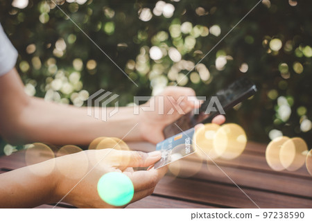 Close up hand of woman using credit card and smartphone during slide screen for finding product purchase buying payments online shopping, making secure internet payment browsing banking service 97238590