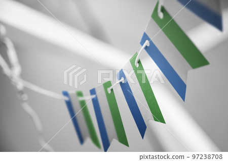 A garland of Sierra Leone national flags on an abstract blurred background 97238708