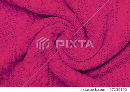 The texture of warm knitted sweater. Beautiful handmade knitted repeating pattern. Demonstrating Pantone color of the year 2023 viva magenta. The texture of warm knitted sweater. Beautiful handmade knitted repeating pattern. Demonstrating Pantone color of the year 2023 viva magenta. 97239160
