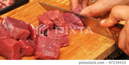 Clean very fresh red raw meat and a sharp knife 97239410