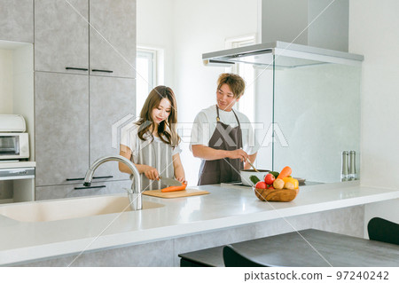 年輕的亞洲夫婦在家裡的廚房裡一起做飯（做家務的男人） 97240242