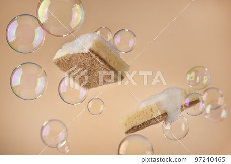 Natural dishwashing sponge with soap bubbles over beige background. Eco friendly housework objects. Natural dishwashing sponge with soap bubbles over beige background. Eco friendly housework objects. 97240465