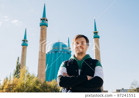 Looking away european caucasian white young male man against Muslim Mosque (Mashkhur Jusup Central Mosque) and autumn leaves trees. Waist up lifestyle travel portrait, religion concept. Looking away european caucasian white young male man against Muslim Mosque (Mashkhur Jusup Central Mosque) and autumn leaves trees. Waist up lifestyle travel portrait, religion concept. 97241551