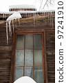 Icy, small icicles hang on the edge of the roof, winter or spring. 97241910