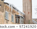 Icy, frozen icicles hang on the edge of the roof, spring or winter.  97241920