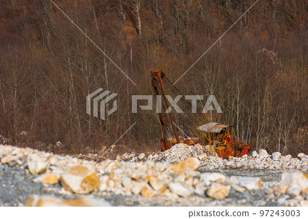 Old broken abandoned rusty excavator in a quarry 97243003