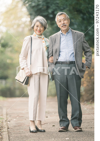 Classy senior couple smiling outdoors 97243170