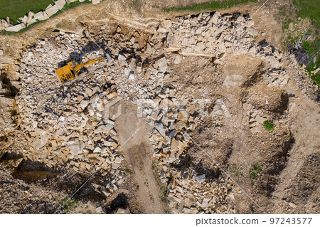 Aerial view of excavator working in a limestone quarry Aerial view of excavator working in a limestone quarry 97243577