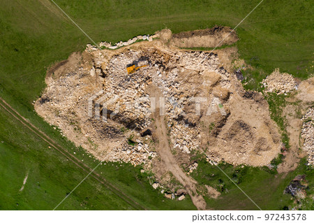 Aerial view of excavator working in a limestone quarry Aerial view of excavator working in a limestone quarry 97243578