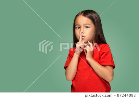 girl placing finger on lips asking shh, quiet, silence 97244098
