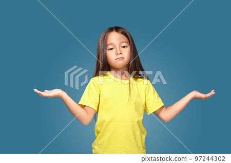 Surprised girl with spread arms on blue background 97244302