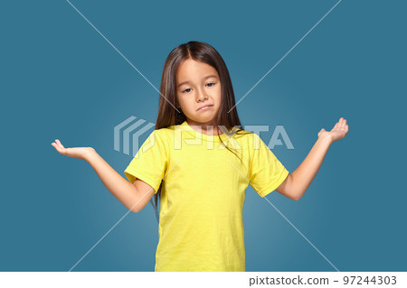 Surprised girl with spread arms on blue background 97244303
