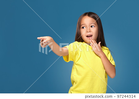 Cute girl shows finger on blue background 97244314