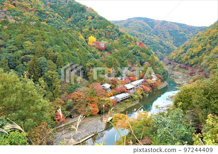 It is Arashiyama, Hozukyo, the flow of the Katsura River, and the village in the valley. Boating boats were arriving and departing. 97244409