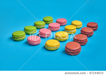 Colored macaron or macaroon, sweet meringue-based confection on blue background. Close-up, copy space. 97244633