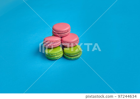 Colored macaron or macaroon, sweet meringue-based confection on blue background. Close-up, copy space. 97244634