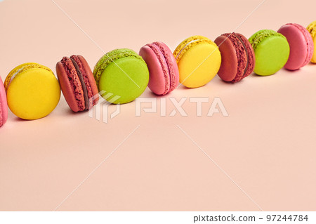 Colored macaron or macaroon, sweet meringue-based confection on pink background. Close-up, copy space. 97244784